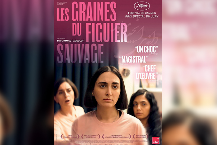 Affiche du film "Les Graines du Figuier Sauvage". On y voit une femme au centre, avec deux autres femmes en arrière-plan.