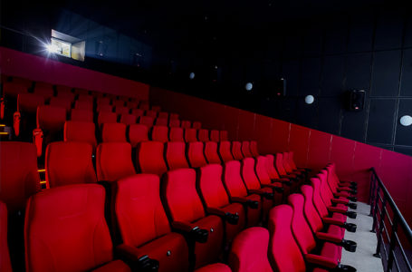 Salle de cinéma avec des sièges rouges.