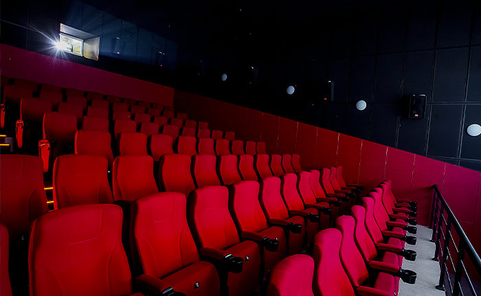 Salle de cinéma avec des sièges rouges.