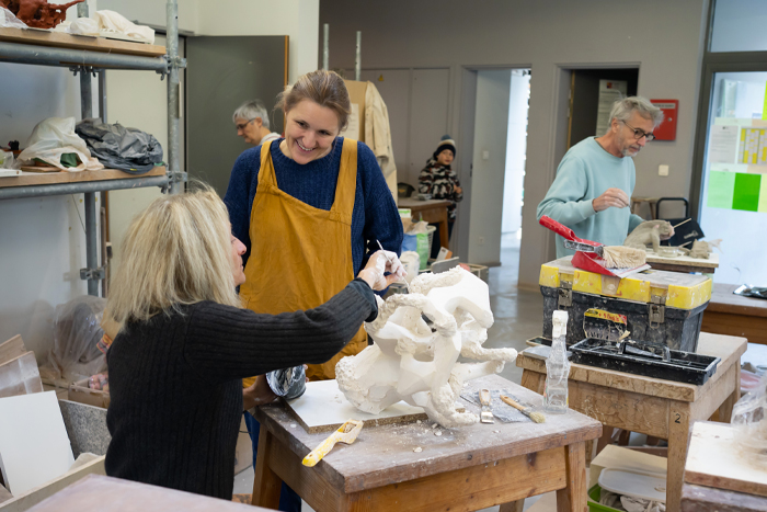 Photo représentant une professeure de sculpture donnant un cours à une autre femme