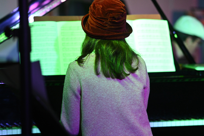 photo d'une femme de dos qui joue au piano