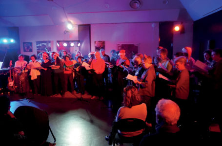 photo représentant une vingtaine de personnes debout en train de chanter