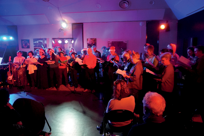 photo représentant une vingtaine de personnes debout en train de chanter
