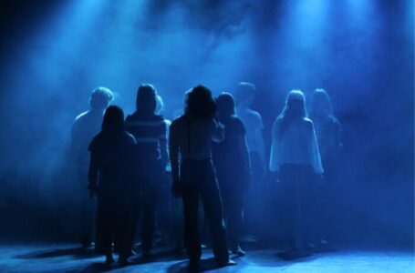 enfants de dos sur une scène en train de jouer une pièce de théâtre