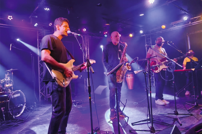 Photo représentant un concert avec un bassiste, un pianiste, un trompettiste et deux saxophonistes