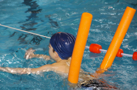enfant en train d'apprendre à nager avec une bouée