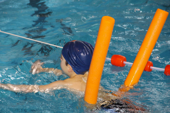 enfant en train d'apprendre à nager avec une bouée